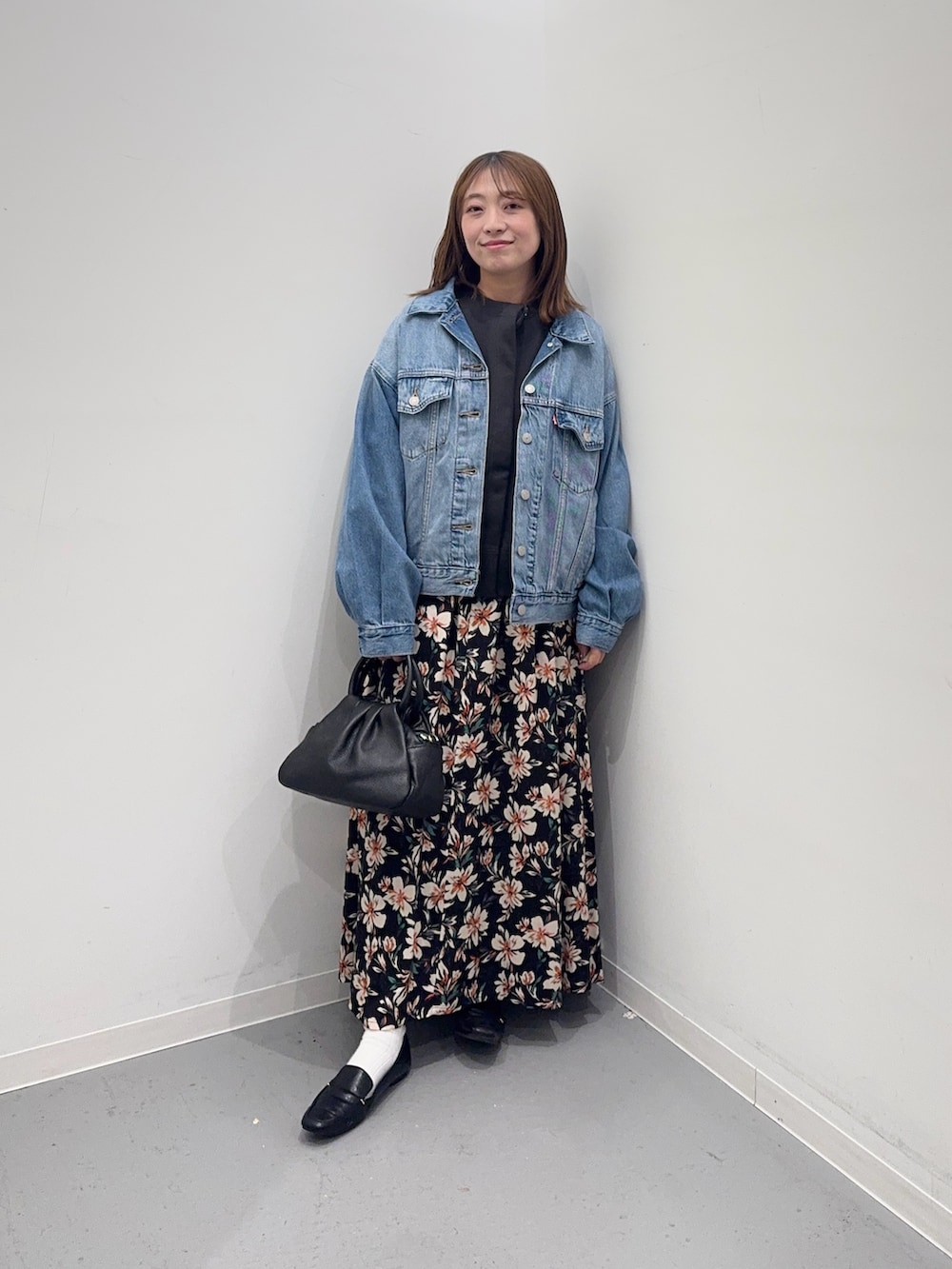 ブルー系のデニムジャケット、グレー系のカーディガン/ボレロ、ブラック系のスカートを着用したレディースの冬コーディネートの4枚目の写真