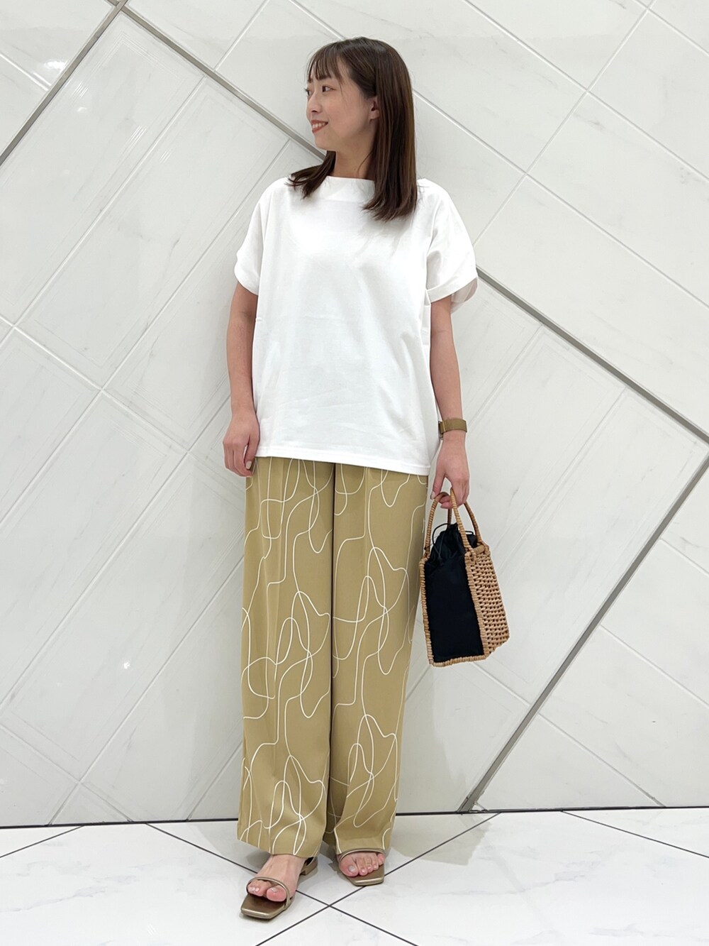 ホワイト系のTシャツ/カットソー、ベージュ系のその他パンツ、ゴールド系のサンダルを着用したレディースの夏コーディネートの5枚目の写真