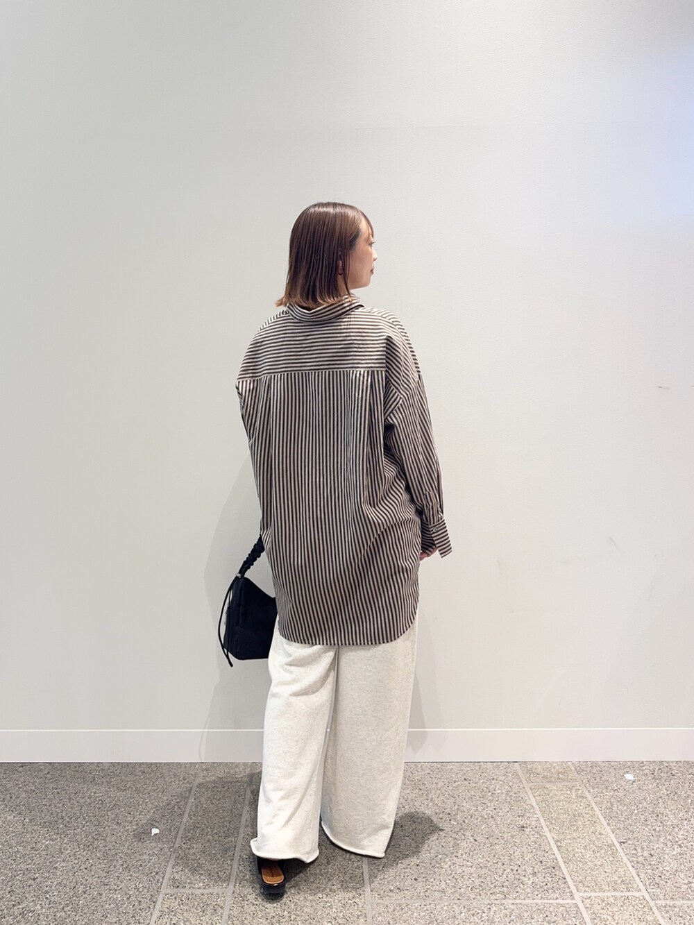 レッド系のシャツ/ブラウス、ベージュ系のその他パンツ、ブラック系のショルダーバッグを着用したレディースの秋コーディネートの4枚目の写真