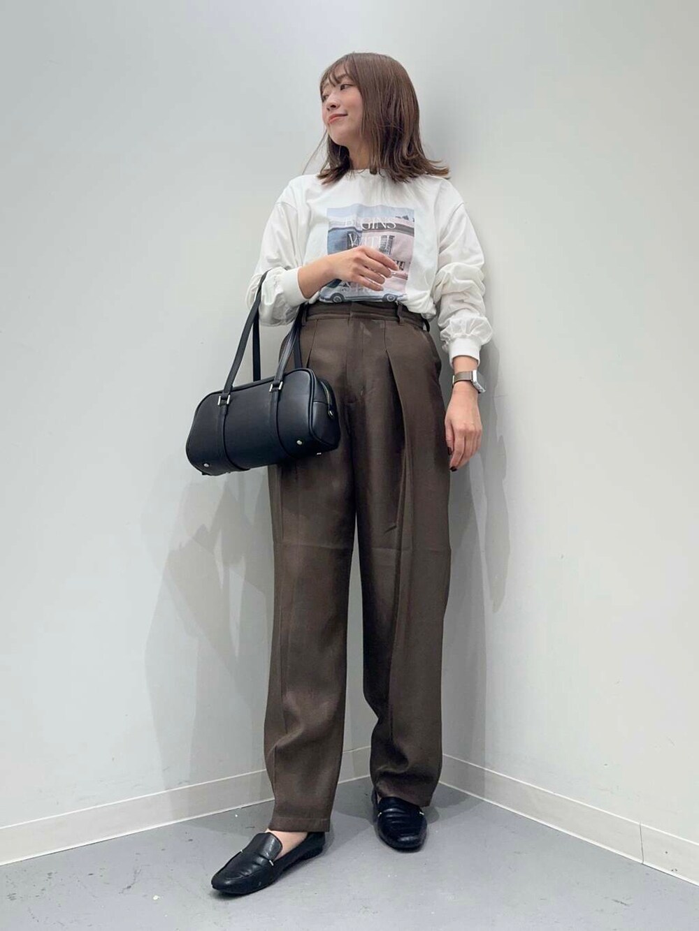 ブラック系のローファー、ブラック系のボストンバッグ、ブラウン系のその他パンツを着用したレディースの秋コーディネートの4枚目の写真