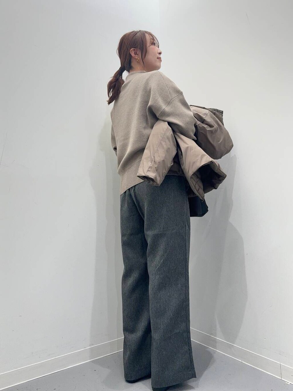グレー系のその他パンツ、ベージュ系のニット/セーター、ブラウン系のダウンジャケット/コートを着用したレディースの冬コーディネートの6枚目の写真