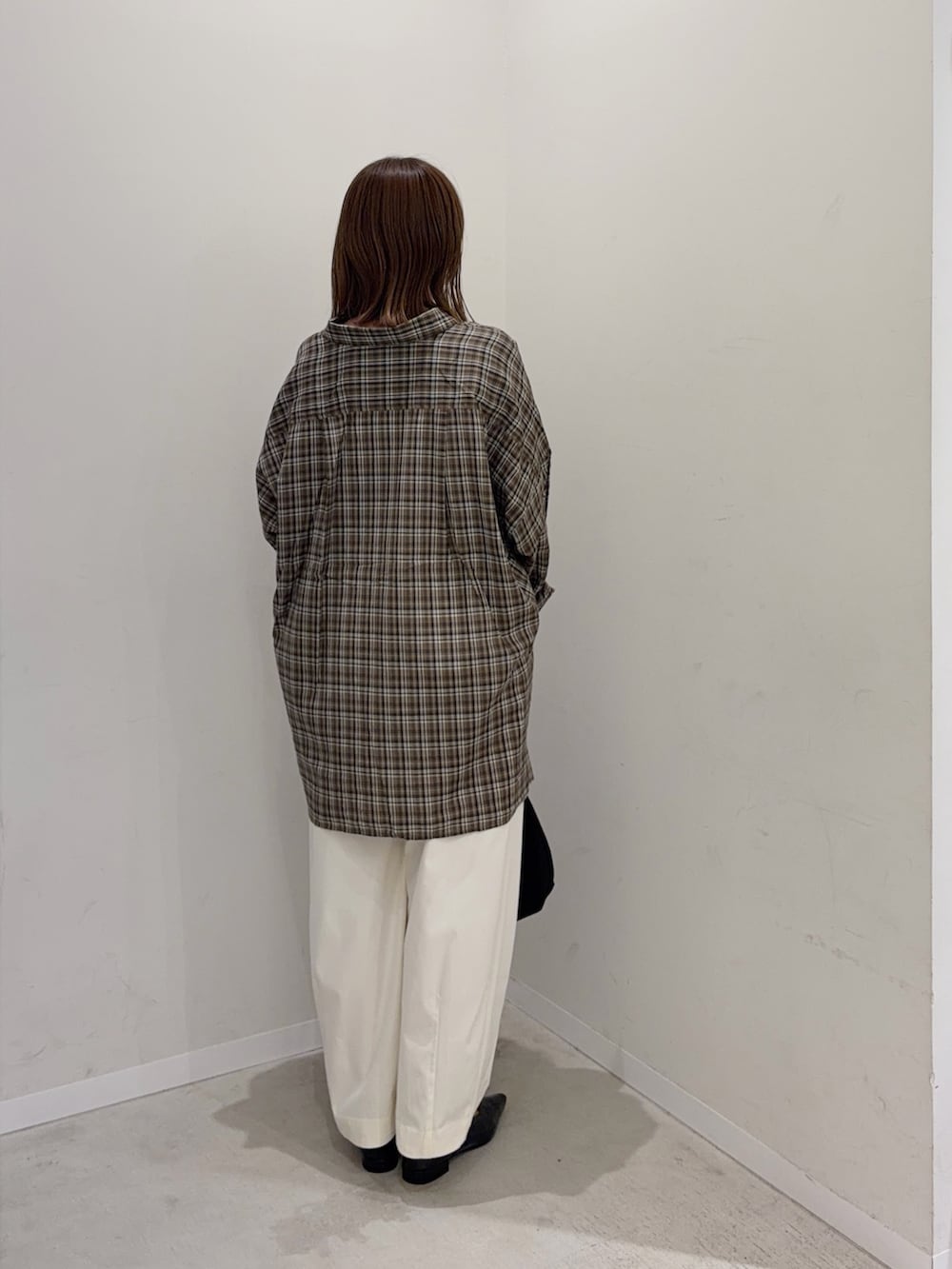 ブラウン系のシャツ/ブラウス、ホワイト系のその他パンツ、ブラック系のトートバッグを着用したレディースの秋コーディネートの3枚目の写真