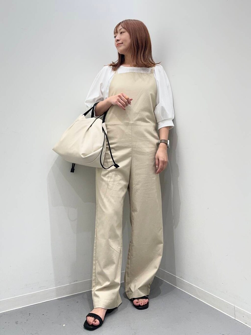 ブラック系のサンダル、ホワイト系のショルダーバッグ、ホワイト系のTシャツ/カットソーを着用したレディースの夏コーディネートの2枚目の写真