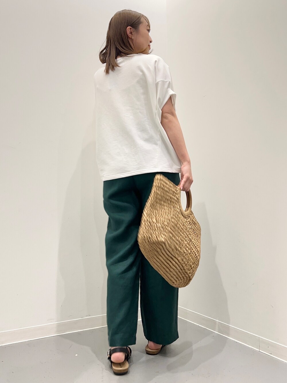 ホワイト系のTシャツ/カットソー、ベージュ系のかごバッグ、グリーン系のその他パンツを着用したレディースの春コーディネートの5枚目の写真