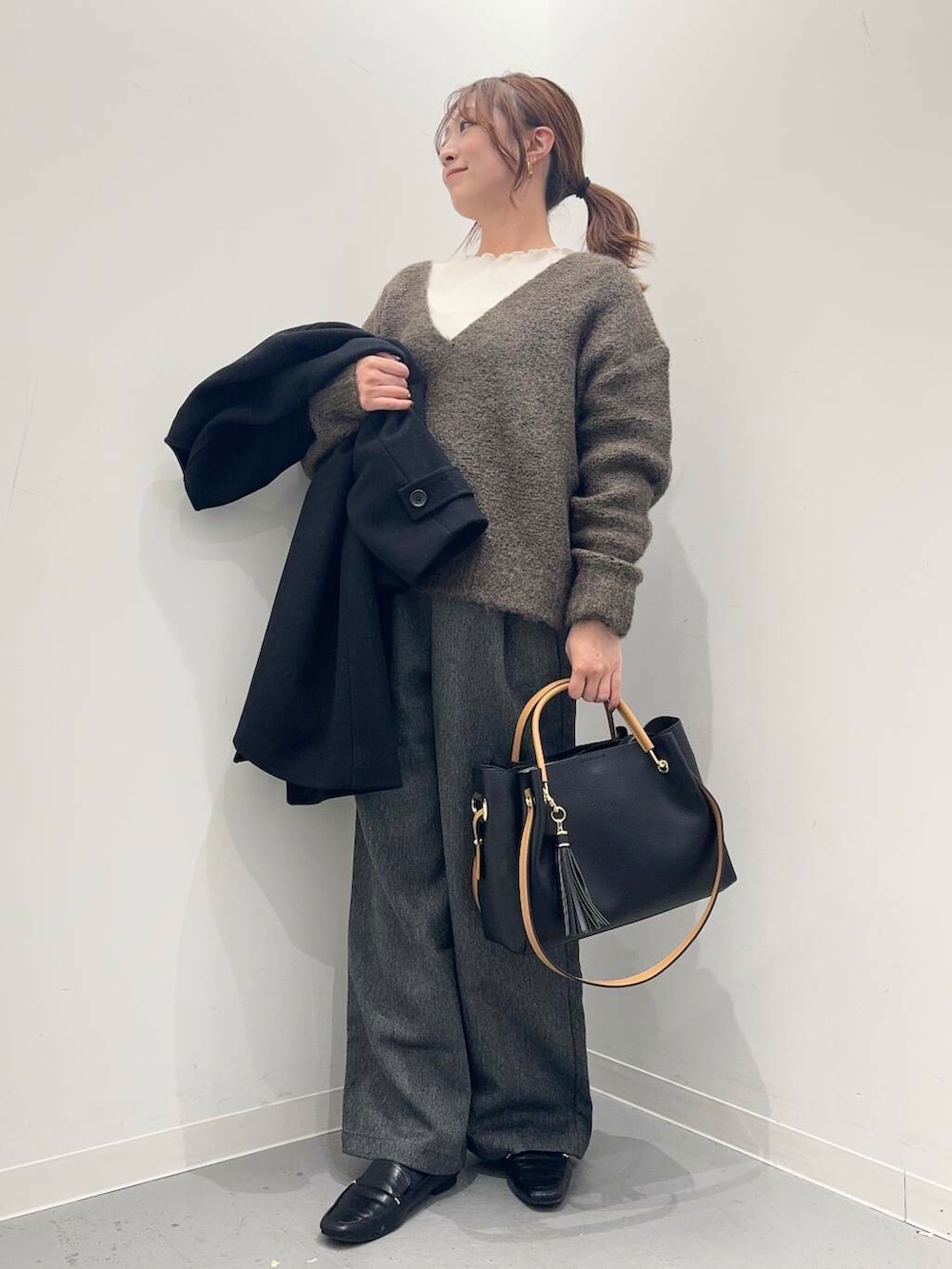 ブラック系のローファー、ブラック系のトートバッグ、ブラック系のその他アウターを着用したレディースの冬コーディネートの6枚目の写真