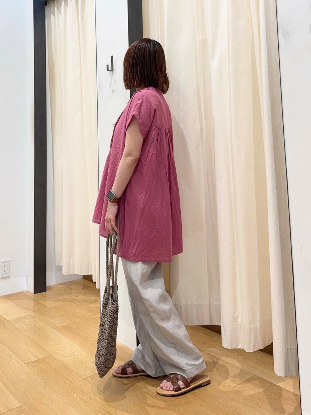 ブラウン系のサンダル、グレー系のトートバッグ、ピンク系のTシャツ/カットソーを着用したレディースの夏コーディネートの3枚目の写真