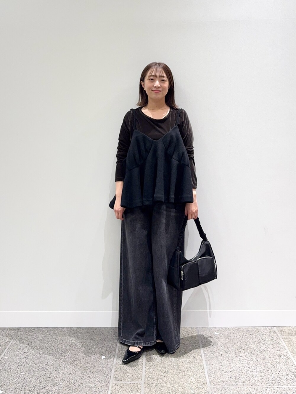 ブラック系のキャミソール、ブラウン系のTシャツ/カットソー、ブラック系のパンプスを着用したレディースの秋コーディネートの6枚目の写真