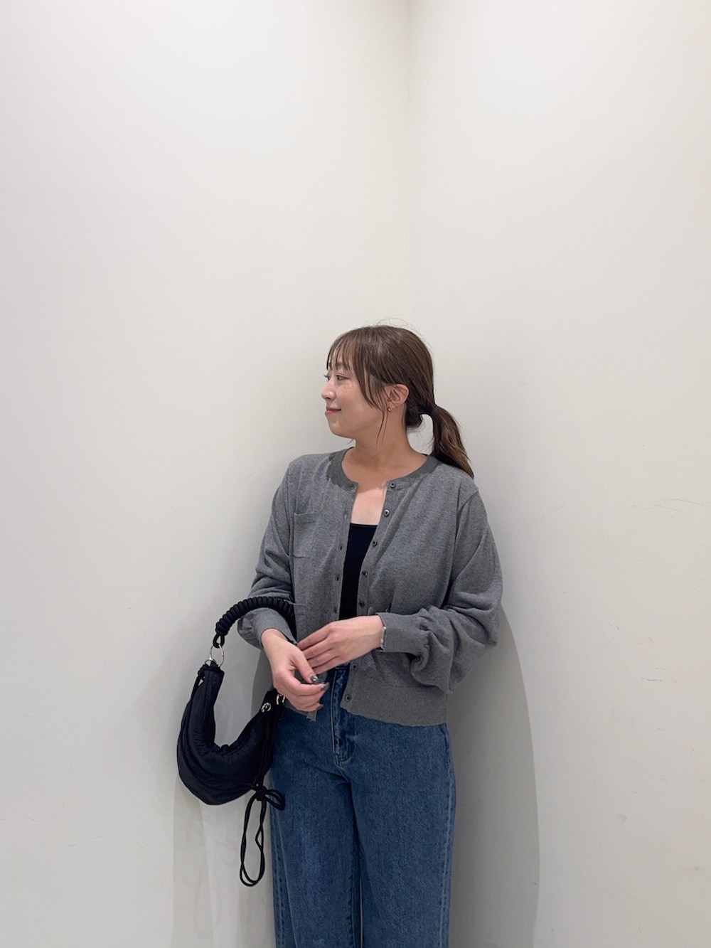 グレー系のカーディガン/ボレロ、ブルー系のデニムパンツ、ブラック系のハンドバッグを着用したレディースの夏コーディネートの5枚目の写真