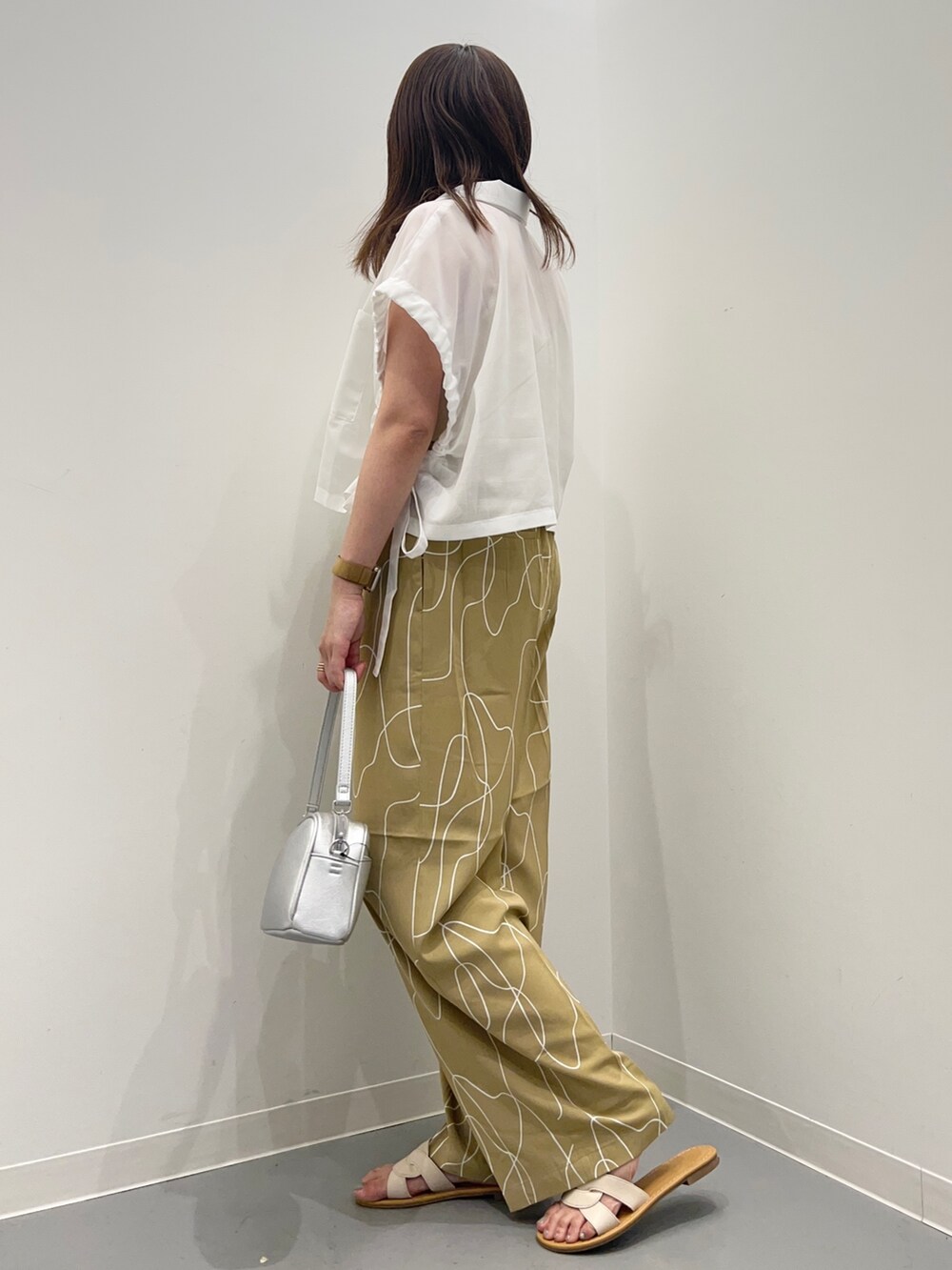 ホワイト系のシャツ/ブラウス、ベージュ系のその他パンツ、ホワイト系のサンダルを着用したレディースの夏コーディネートの4枚目の写真