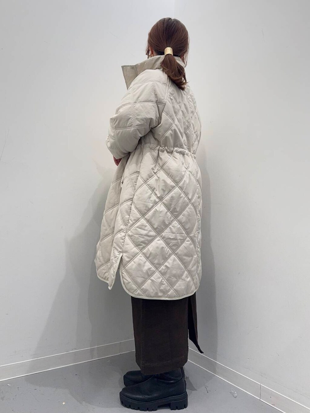 ホワイト系のショルダーバッグ、ブラック系のブーツ、ベージュ系のその他アウターを着用したレディースの冬コーディネートの8枚目の写真