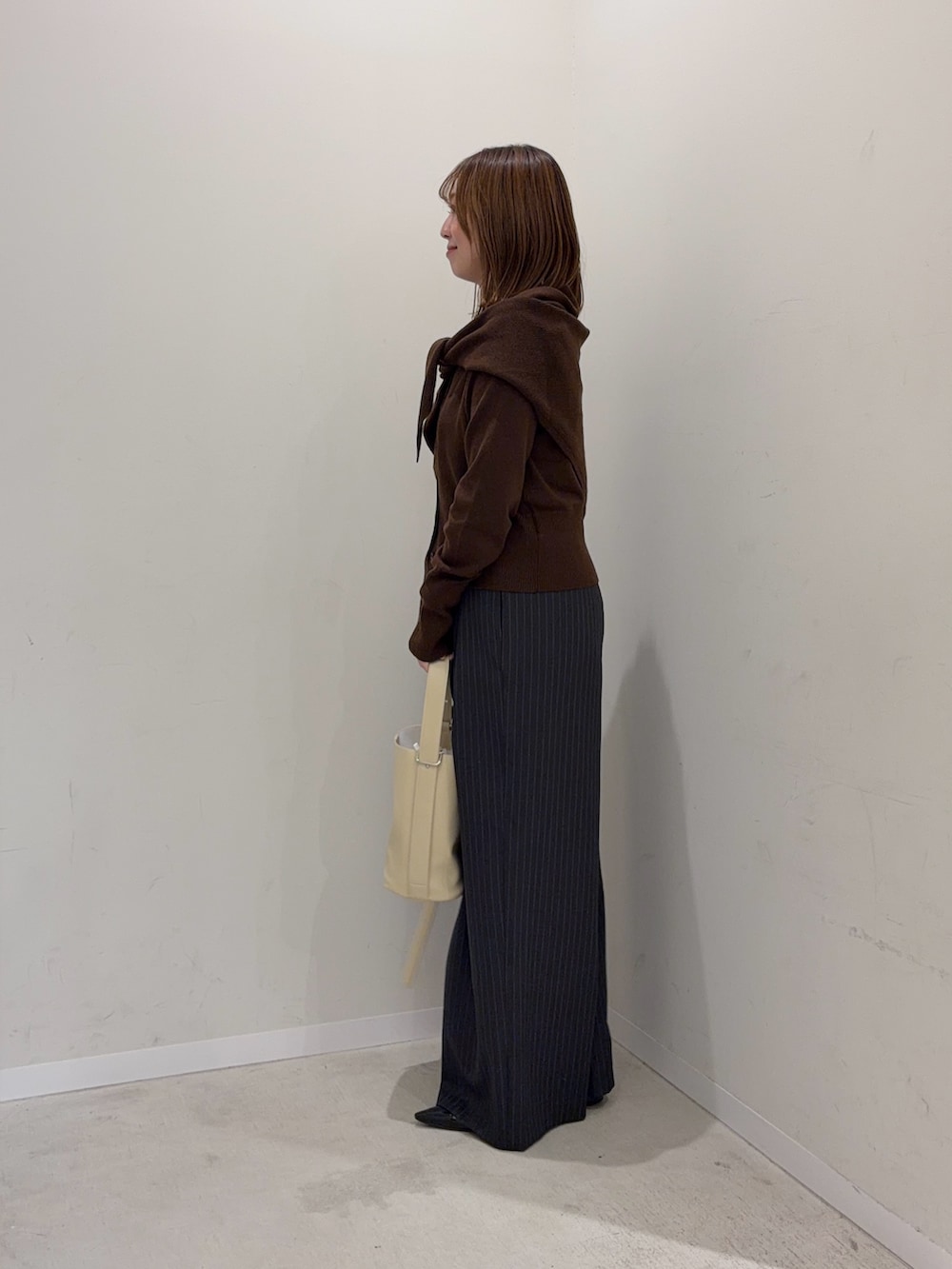 ブラウン系のカーディガン/ボレロ、グレー系のその他パンツ、ベージュ系のショルダーバッグを着用したレディースの秋コーディネートの5枚目の写真