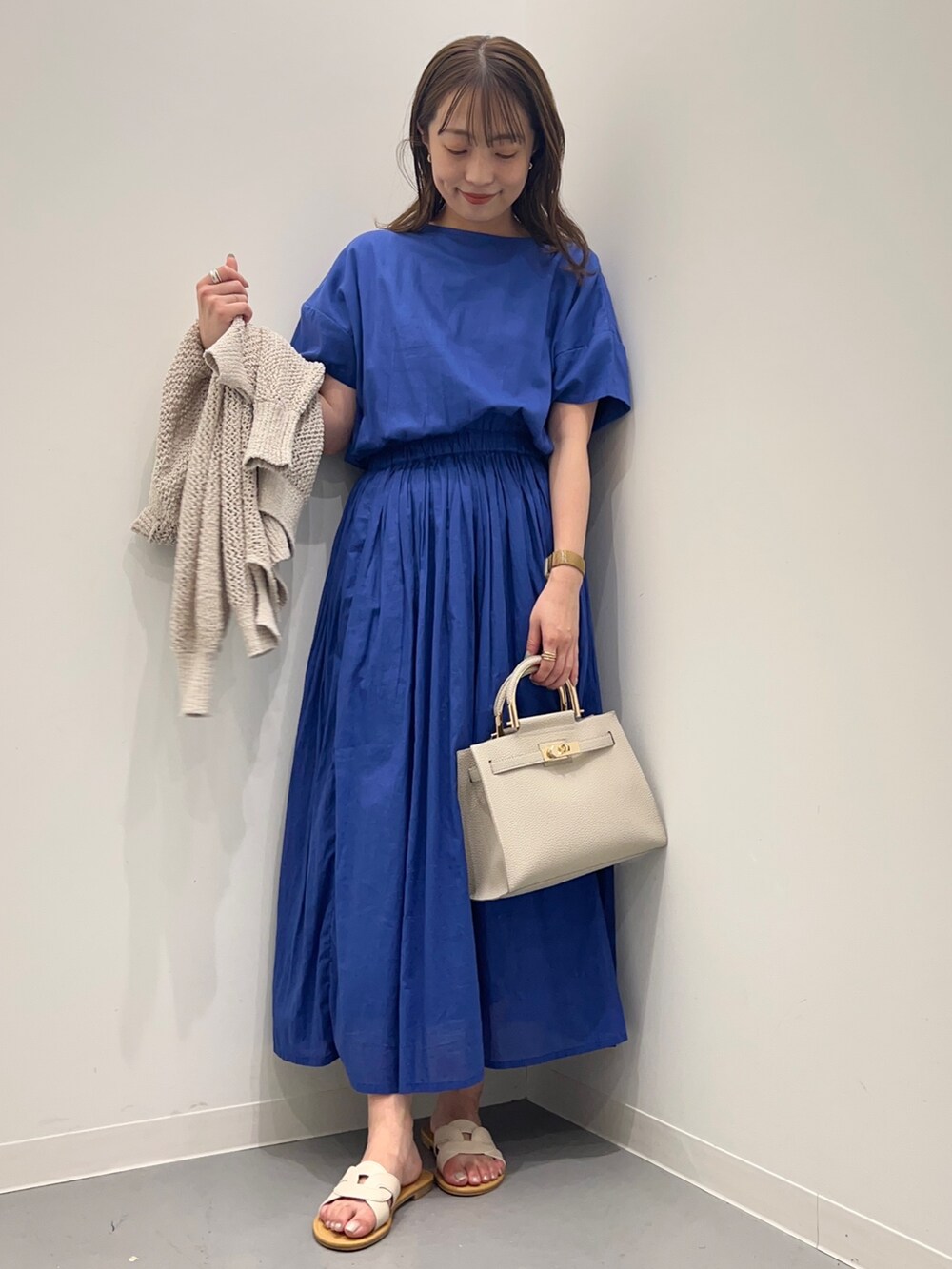 ブルー系のワンピース、ホワイト系のカーディガン/ボレロ、ホワイト系のハンドバッグを着用したレディースの夏コーディネートの6枚目の写真