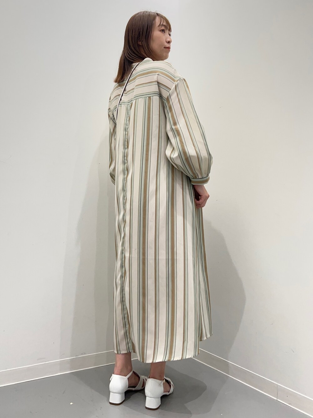 グリーン系のワンピース、ホワイト系のサンダルを着用したレディースの春コーディネートの5枚目の写真