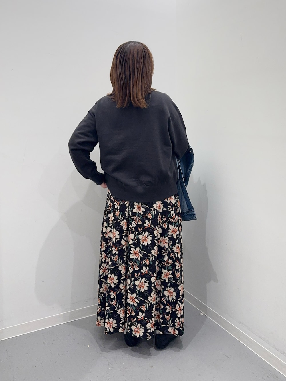 ブルー系のデニムジャケット、グレー系のカーディガン/ボレロ、ブラック系のスカートを着用したレディースの冬コーディネートの6枚目の写真