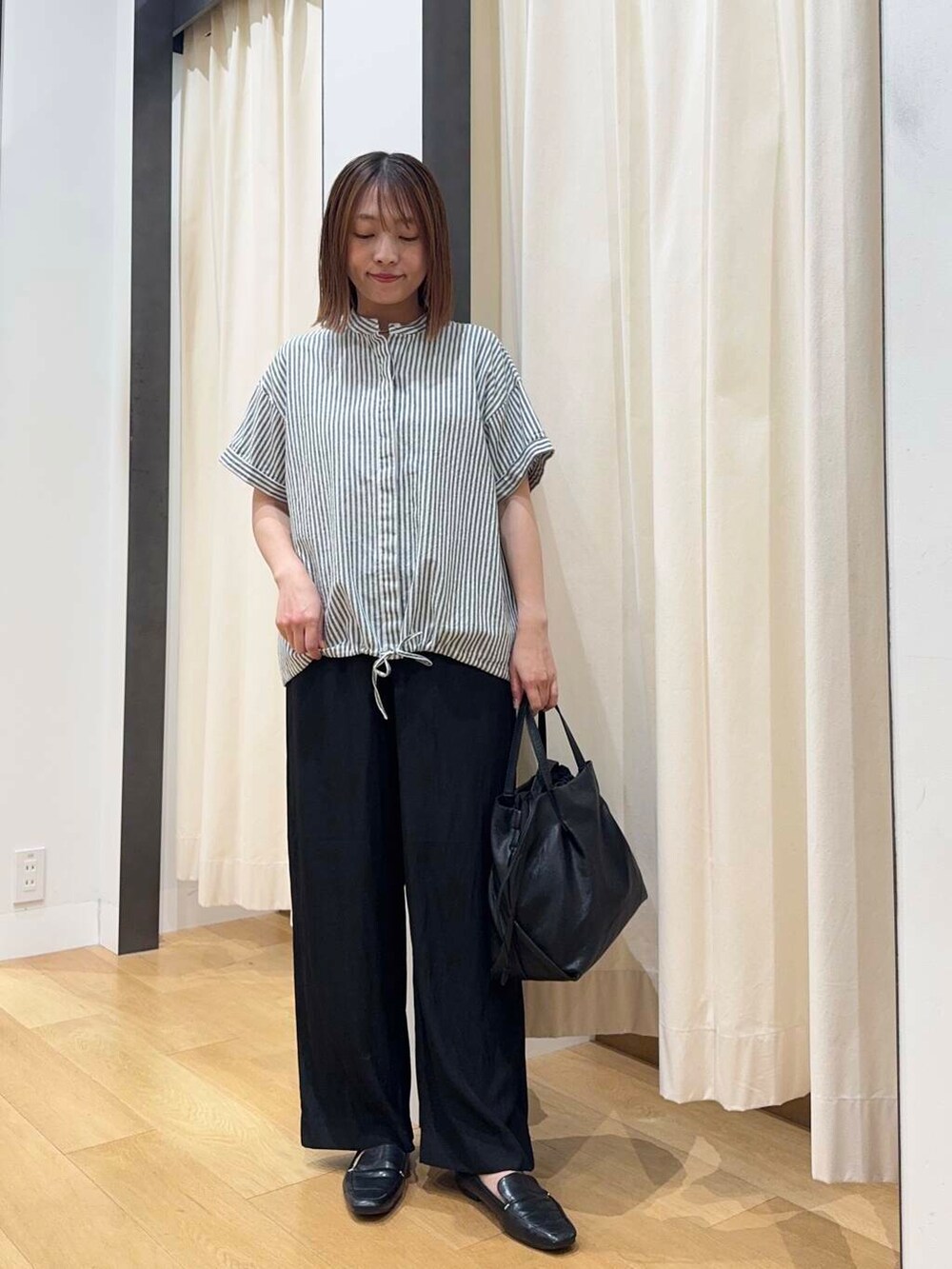 ブラック系のトートバッグ、ブラック系のその他パンツ、ブラック系のローファーを着用したレディースの夏コーディネートの5枚目の写真