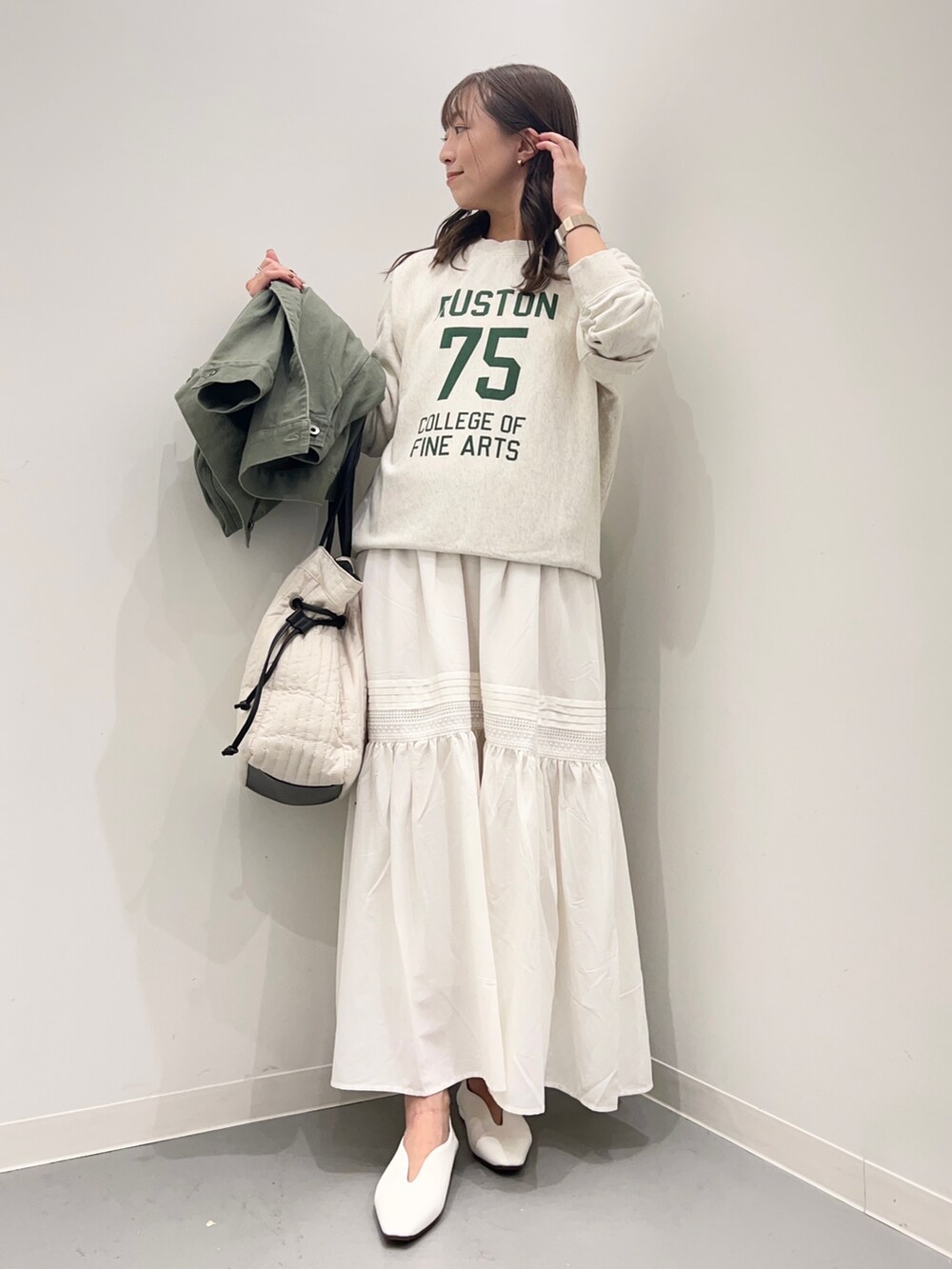 ベージュ系のスウェット、グリーン系のジャケット/アウター、ホワイト系のスカートを着用したレディースの夏コーディネートの5枚目の写真