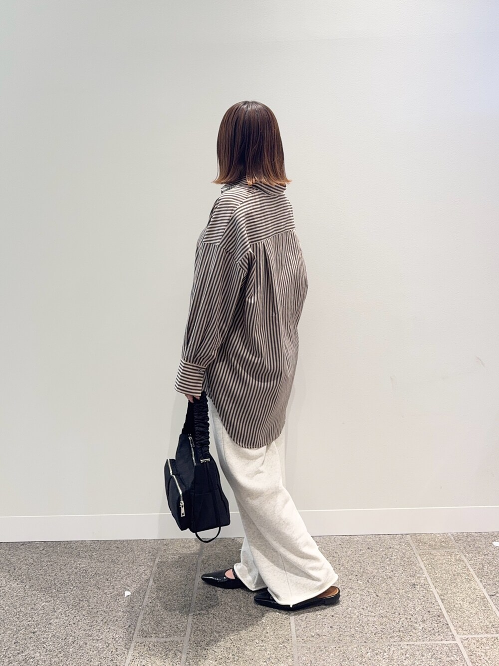 レッド系のシャツ/ブラウス、ベージュ系のその他パンツ、ブラック系のショルダーバッグを着用したレディースの秋コーディネートの3枚目の写真