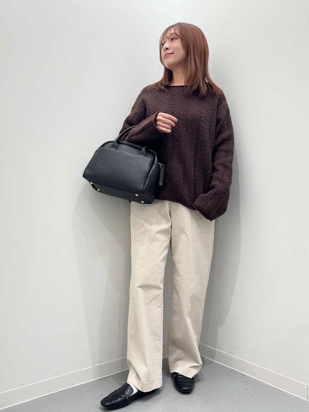 ブラック系のローファー、ブラック系のボストンバッグ、ホワイト系のその他パンツを着用したレディースの冬コーディネートの2枚目の写真