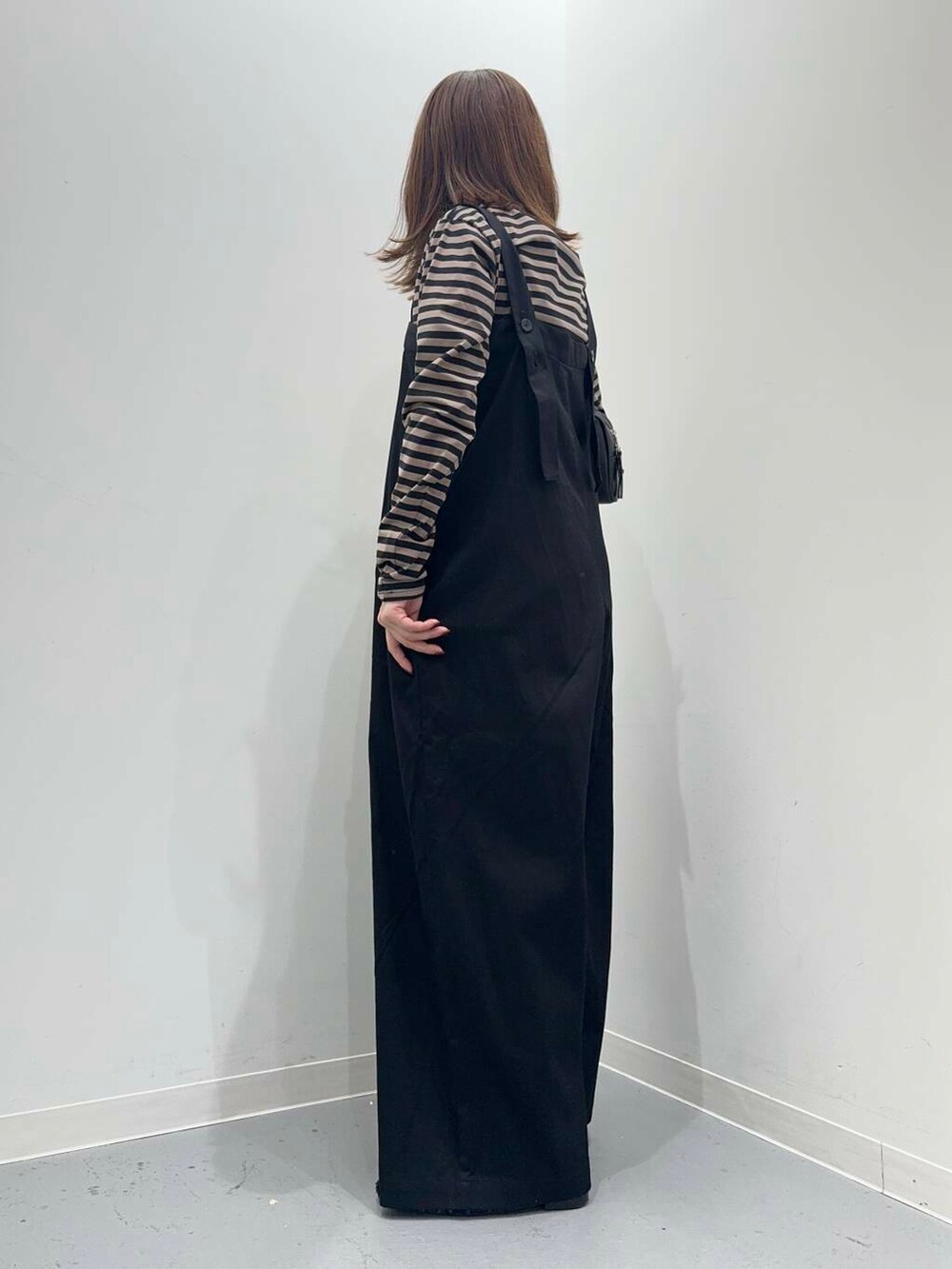 ブラック系のその他シューズ、ブラック系のボストンバッグ、オレンジ系のTシャツ/カットソーを着用したレディースの秋コーディネートの3枚目の写真