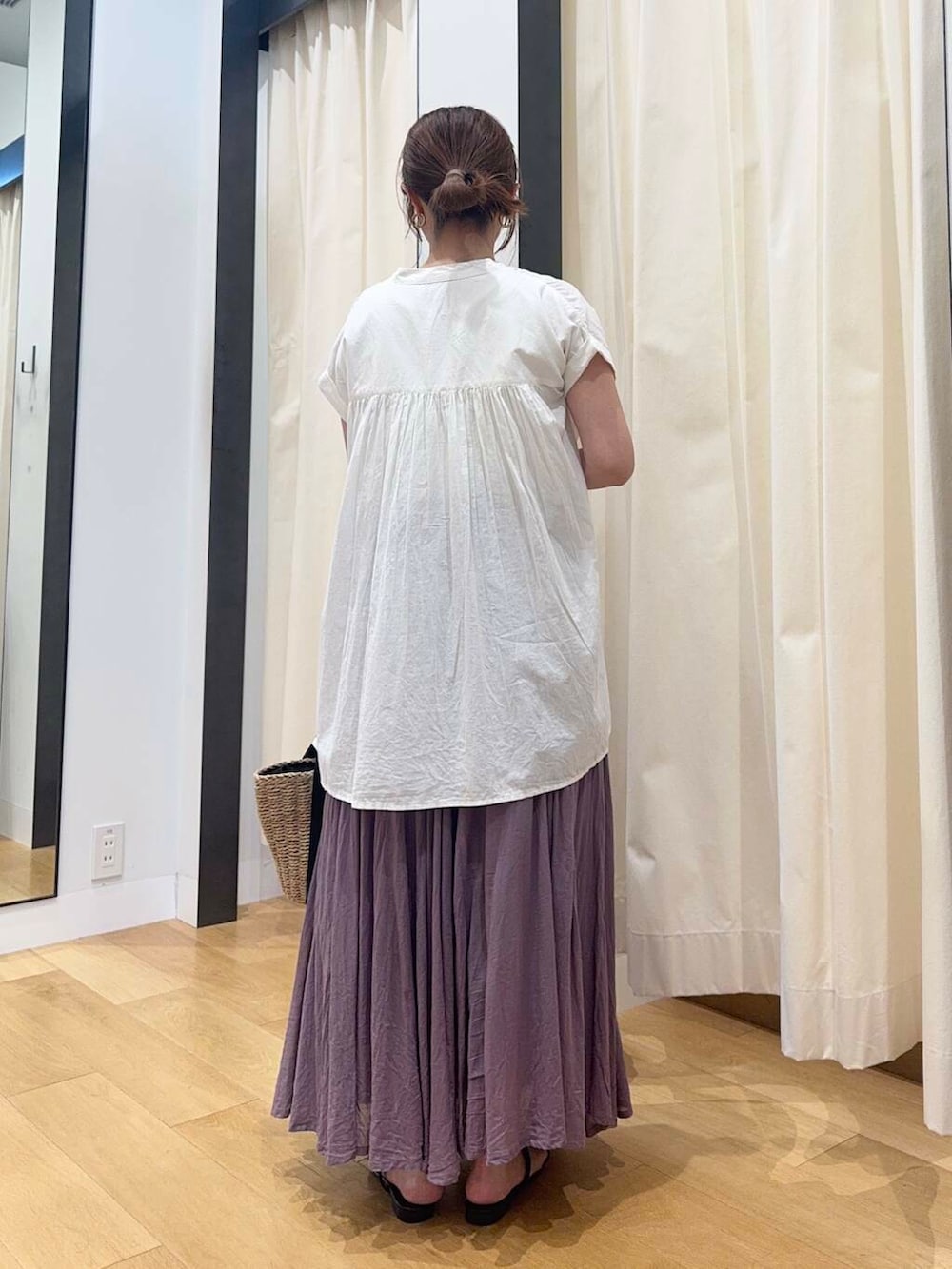 ベージュ系のハンドバッグ、ホワイト系のTシャツ/カットソー、パープル系のスカートを着用したレディースの夏コーディネートの4枚目の写真