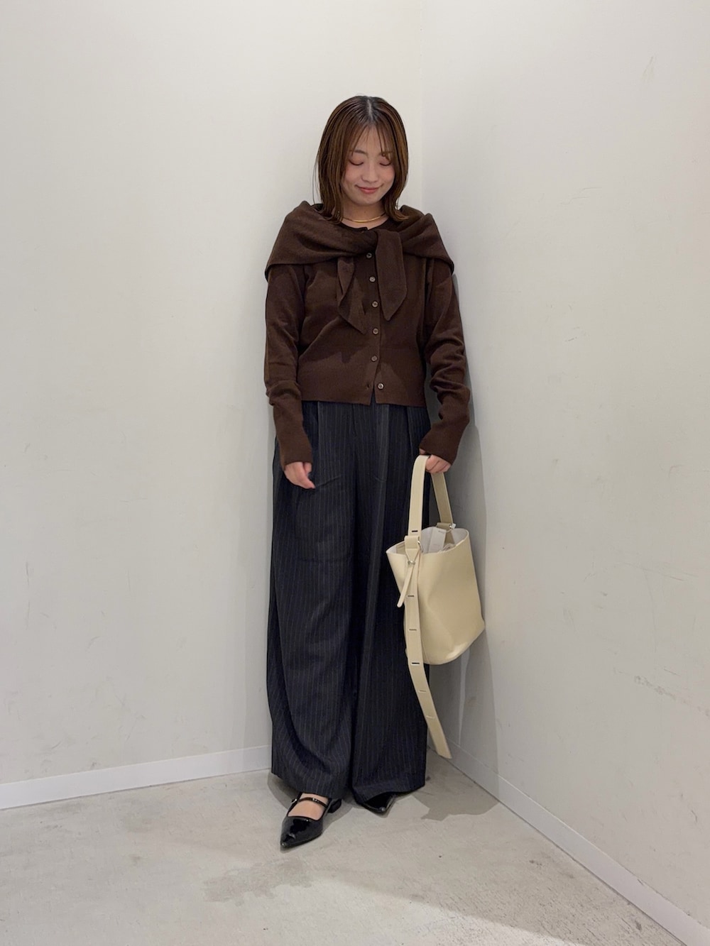 ブラウン系のカーディガン/ボレロ、グレー系のその他パンツ、ベージュ系のショルダーバッグを着用したレディースの秋コーディネートの3枚目の写真