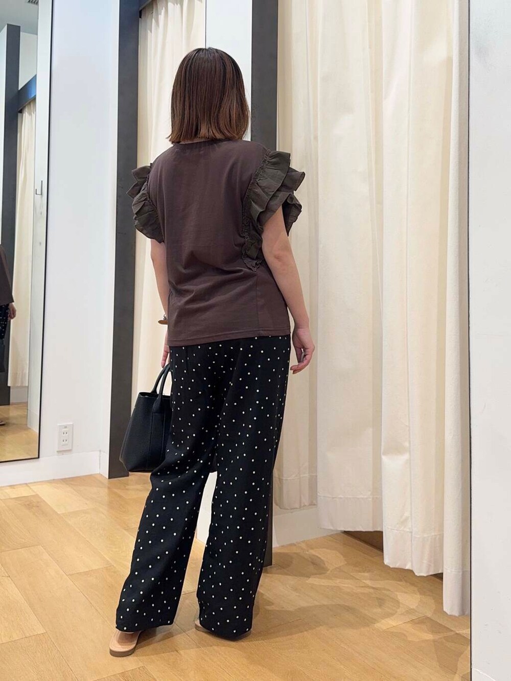 ブラック系のトートバッグ、ブラウン系のサンダル、ブラウン系のTシャツ/カットソーを着用したレディースの夏コーディネートの4枚目の写真