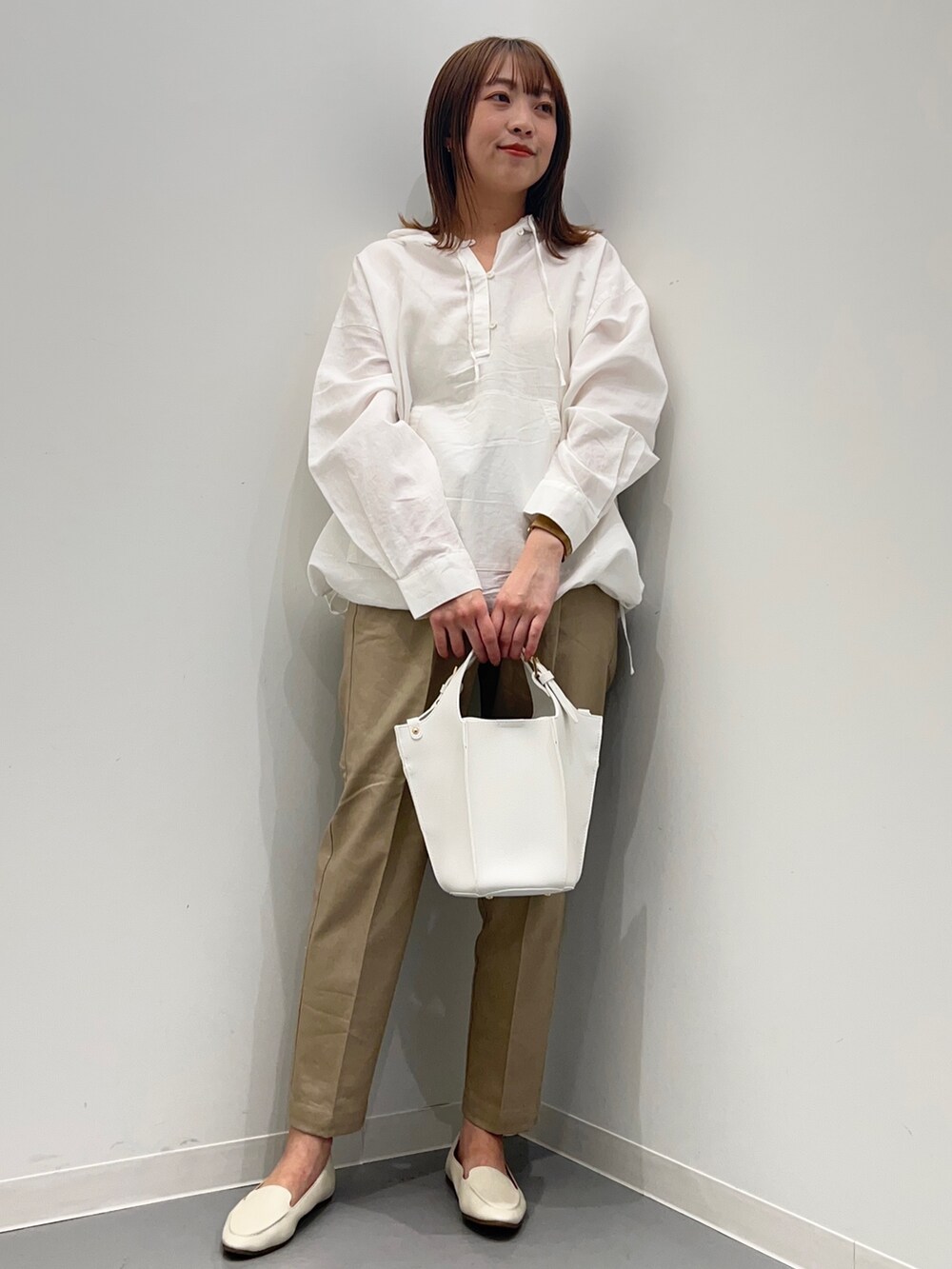 ホワイト系のパーカー、ベージュ系のその他パンツ、ホワイト系のトートバッグを着用したレディースの春コーディネートの2枚目の写真