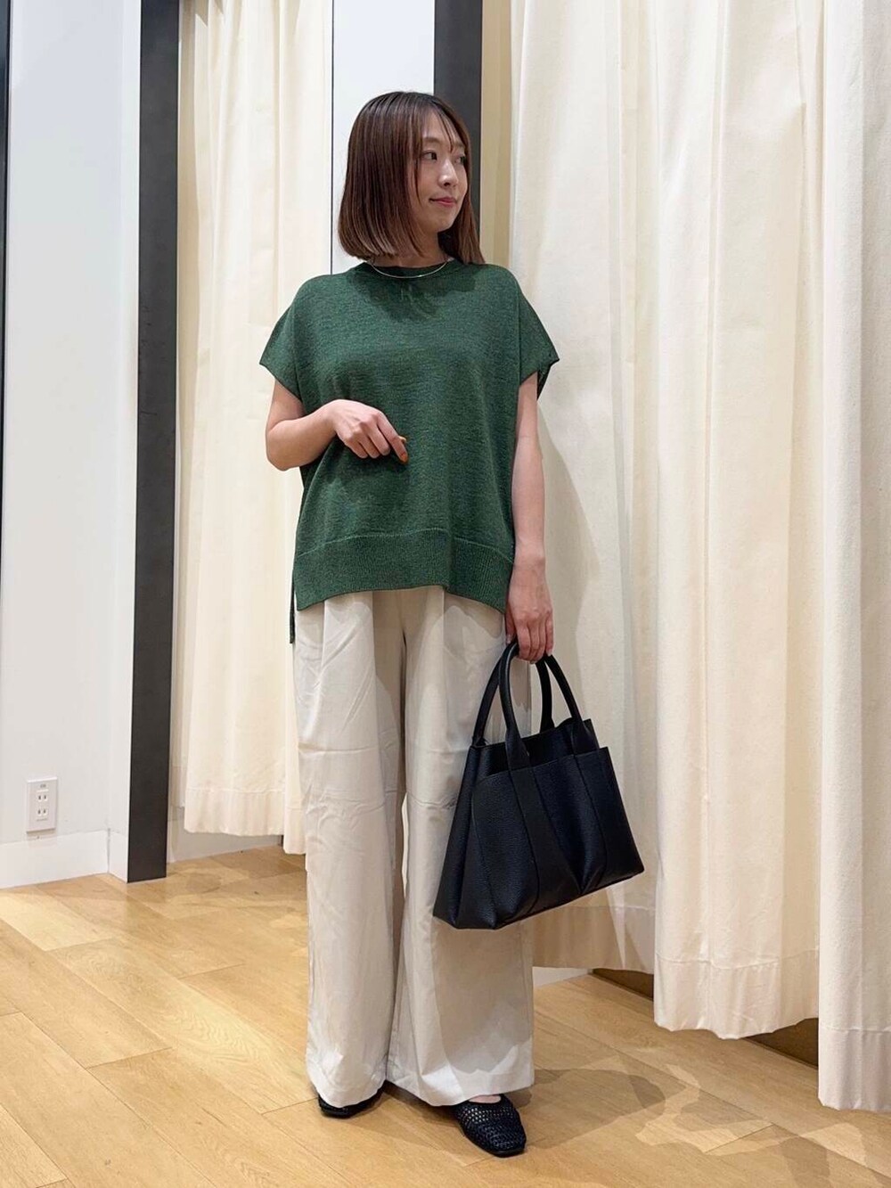 ブラック系のトートバッグ、ブラック系のバレエシューズ、ホワイト系のその他パンツを着用したレディースの夏コーディネートの5枚目の写真