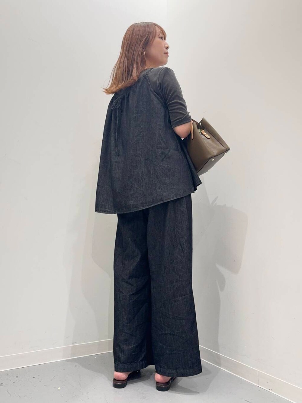 ブラウン系のその他シューズ、グレー系のTシャツ/カットソー、ブラウン系のハンドバッグを着用したレディースの夏コーディネートの4枚目の写真