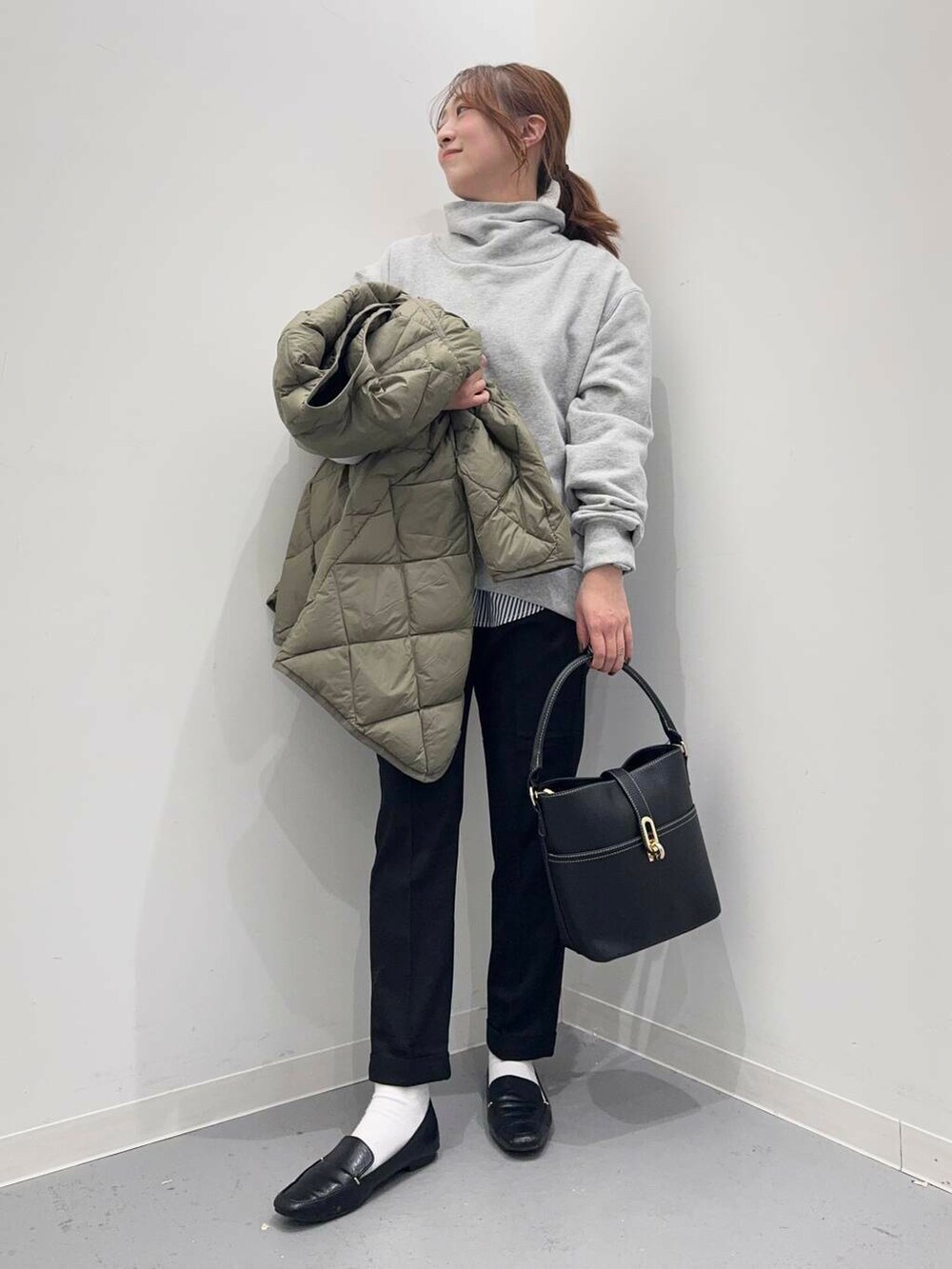 ブラック系のローファー、グリーン系のダウンジャケット/コート、ブルー系のシャツ/ブラウスを着用したレディースの冬コーディネートの9枚目の写真