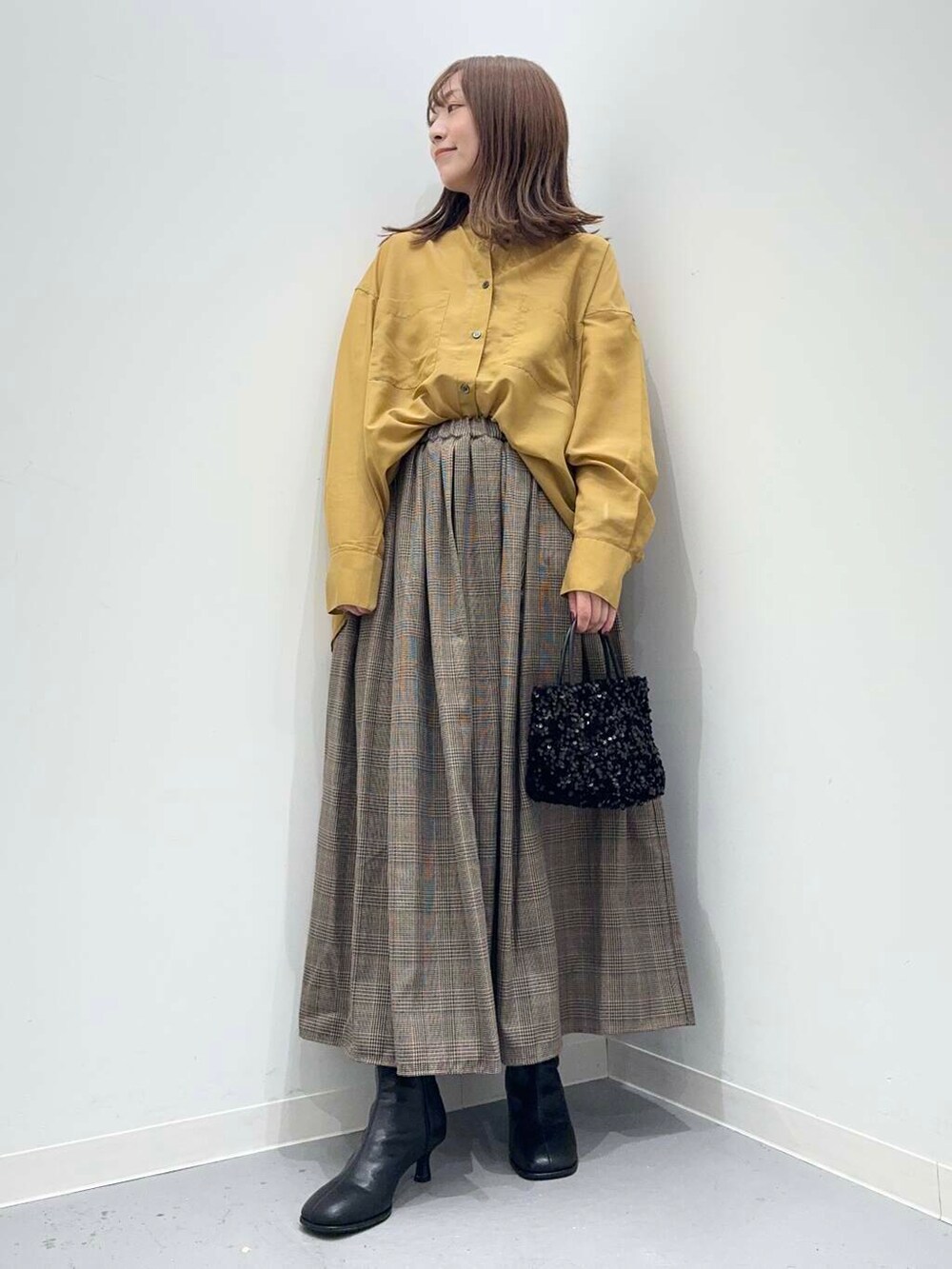 ブラック系のショルダーバッグ、イエロー系のシャツ/ブラウス、その他のスカートを着用したレディースの秋コーディネートの4枚目の写真
