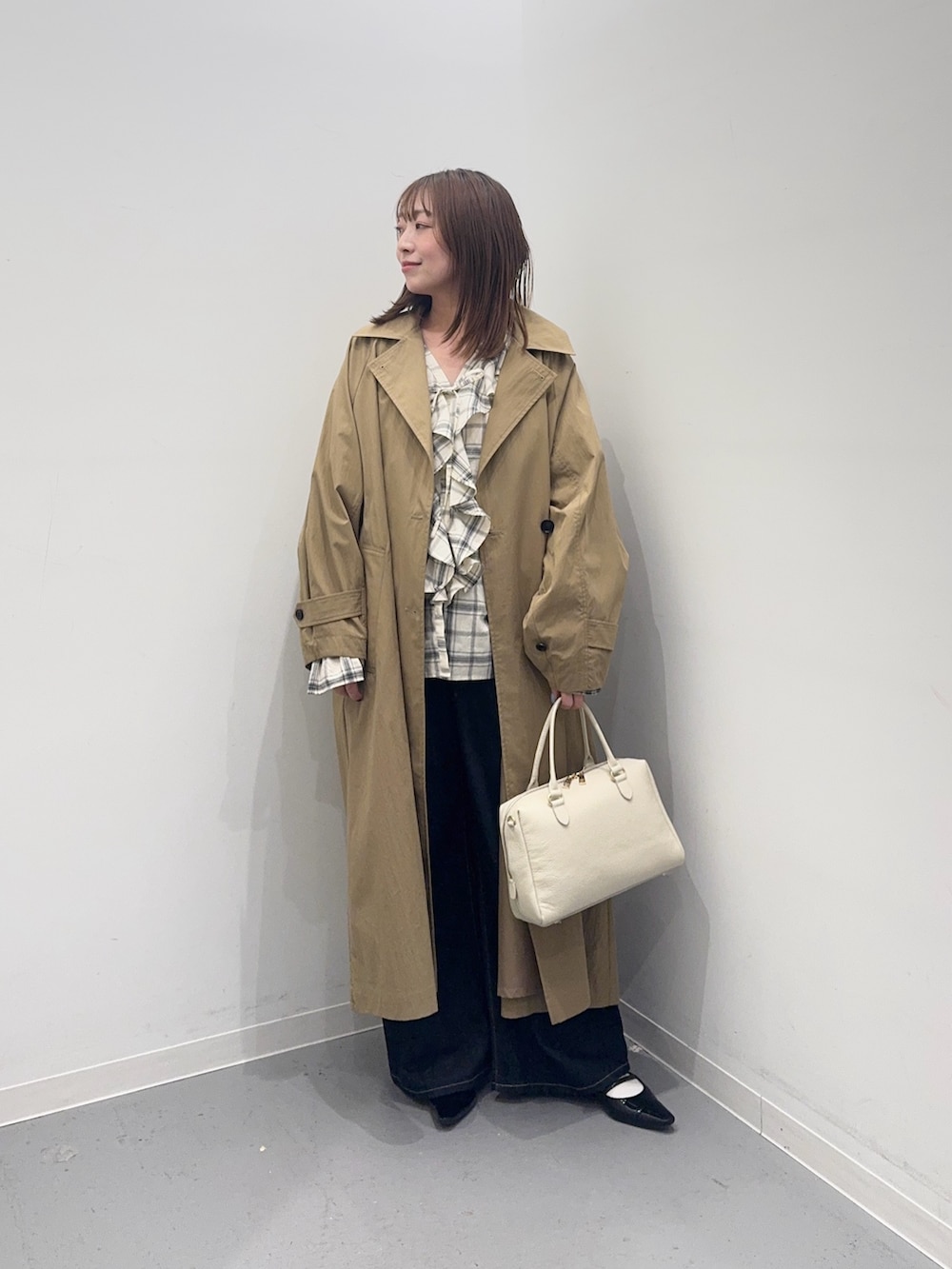 ベージュ系のその他アウター、ブラック系のシャツ/ブラウス、ブルー系のデニムパンツを着用したレディースの春コーディネートの4枚目の写真