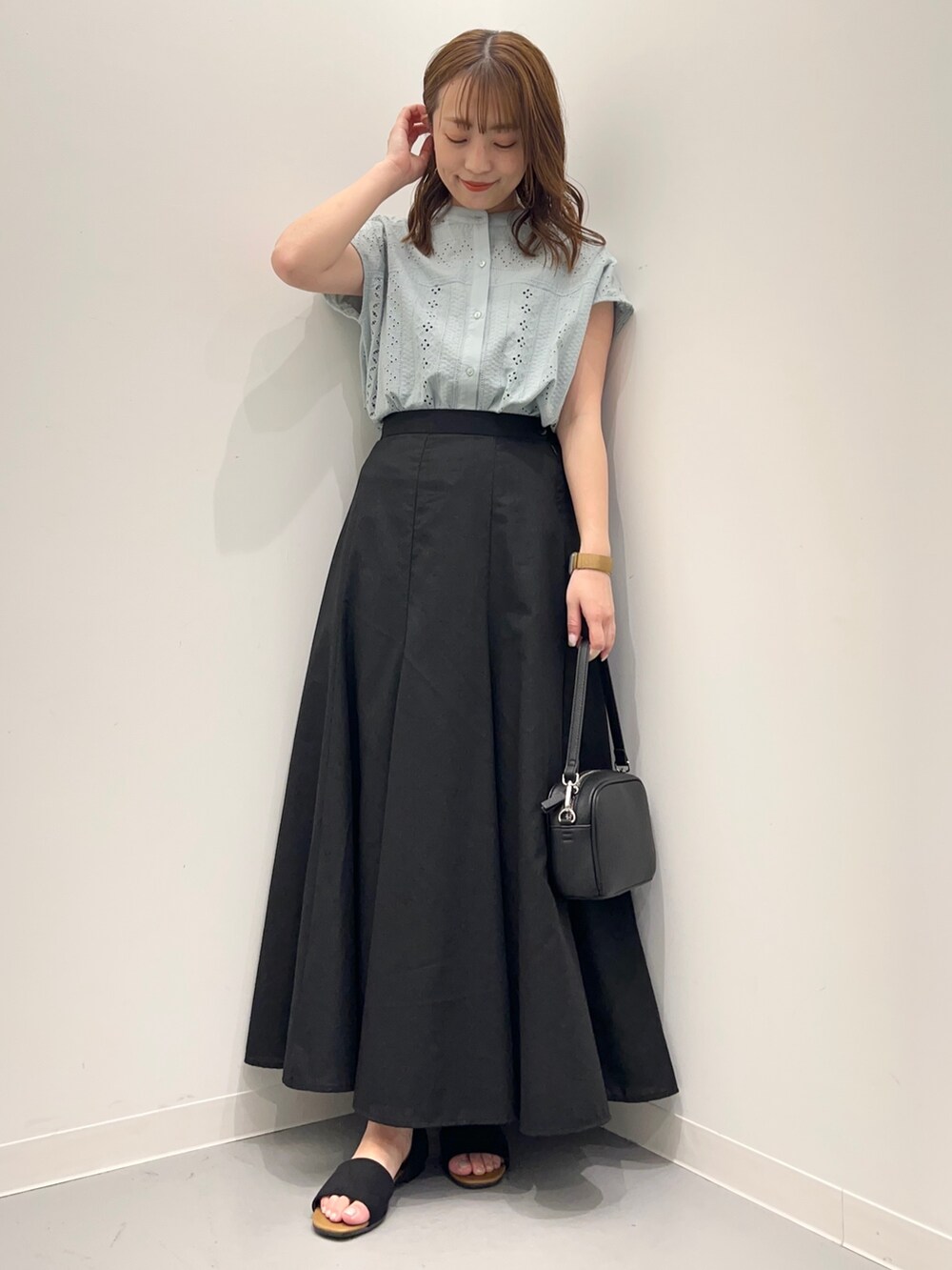 グリーン系のシャツ/ブラウス、ブラック系のスカート、ブラック系のショルダーバッグを着用したレディースの春コーディネートの3枚目の写真