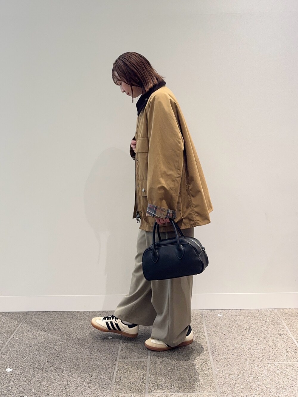 ベージュ系のその他アウター、ブラック系のショルダーバッグ、ベージュ系のスニーカーを着用したレディースの秋コーディネートの3枚目の写真