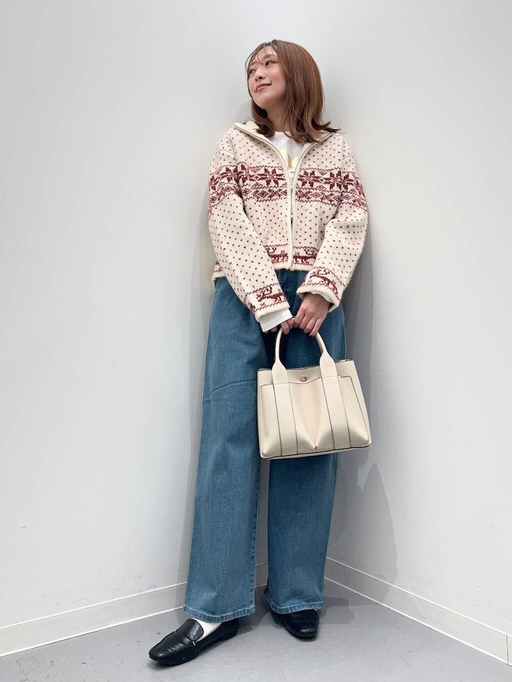 ブラック系のローファー、ホワイト系のトートバッグ、レッド系のニット/セーターを着用したレディースの秋コーディネートの5枚目の写真