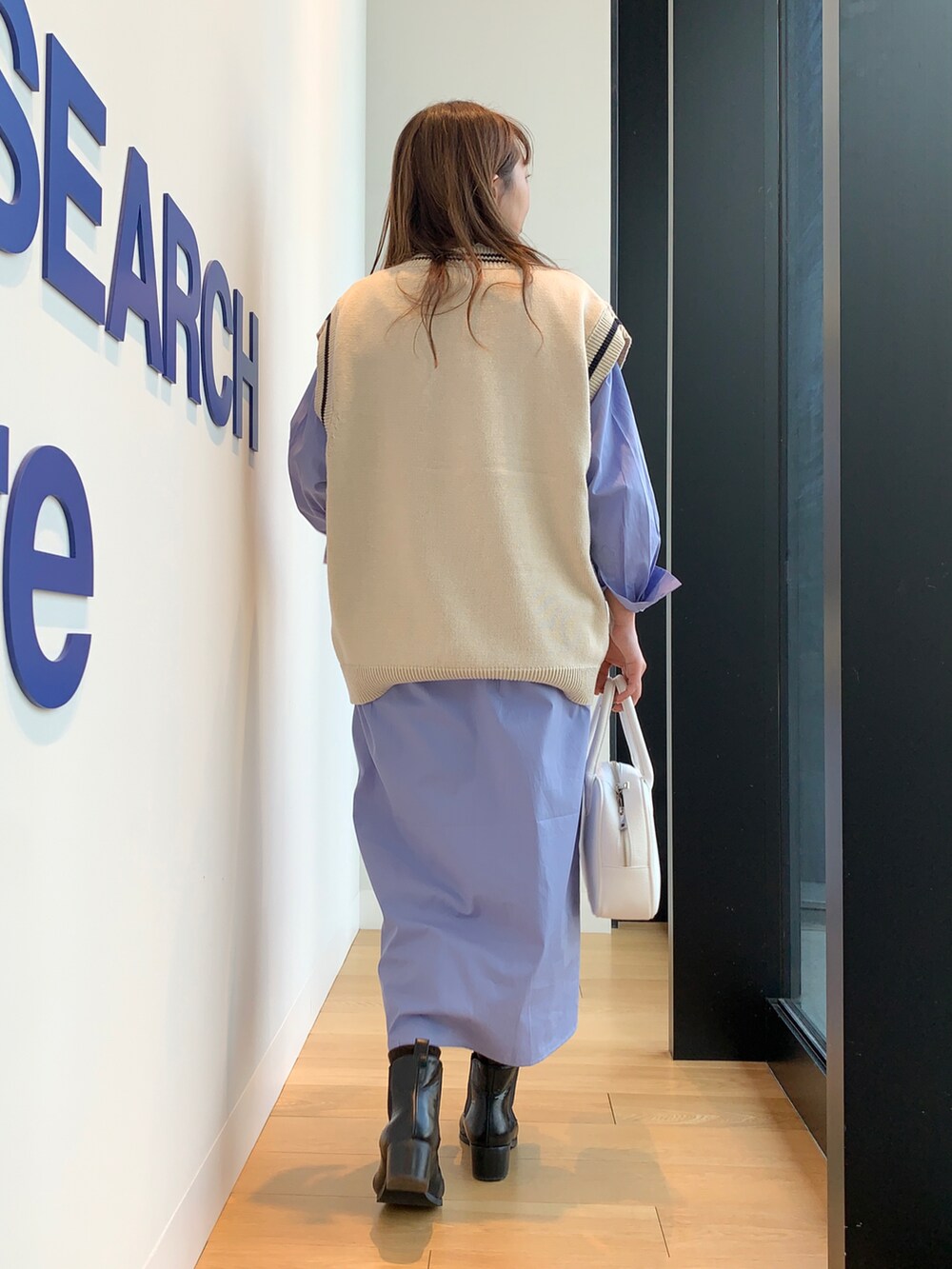 ベージュ系のニット/セーター、ブルー系のワンピース、ホワイト系のボストンバッグを着用したレディースの冬コーディネートの4枚目の写真