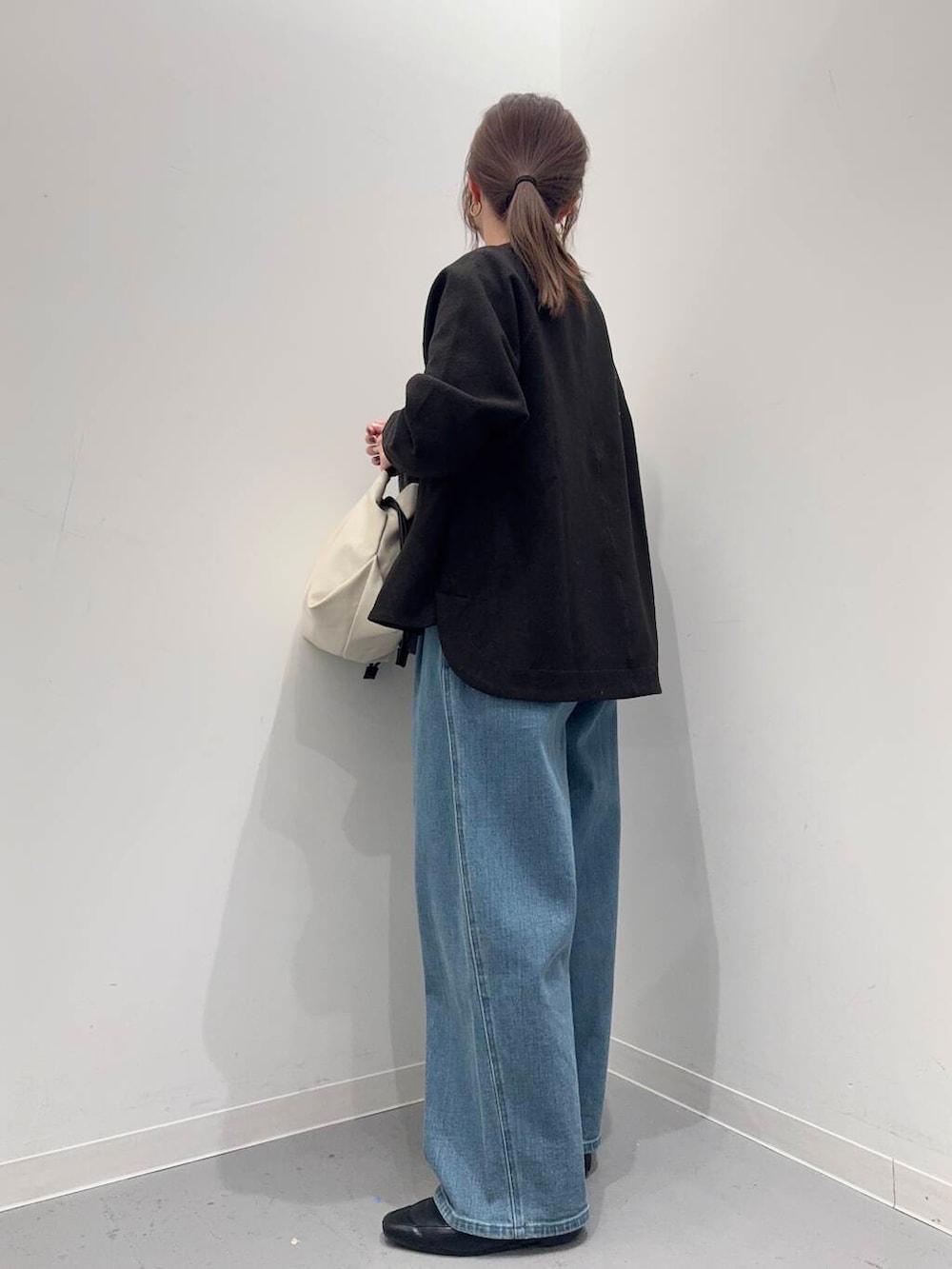 ブラック系のローファー、ホワイト系のショルダーバッグ、グレー系のトレンチコートを着用したレディースの冬コーディネートの6枚目の写真