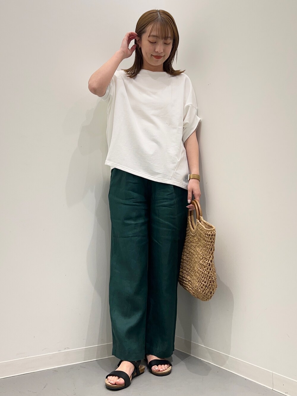 ホワイト系のTシャツ/カットソー、ベージュ系のかごバッグ、グリーン系のその他パンツを着用したレディースの春コーディネートの3枚目の写真