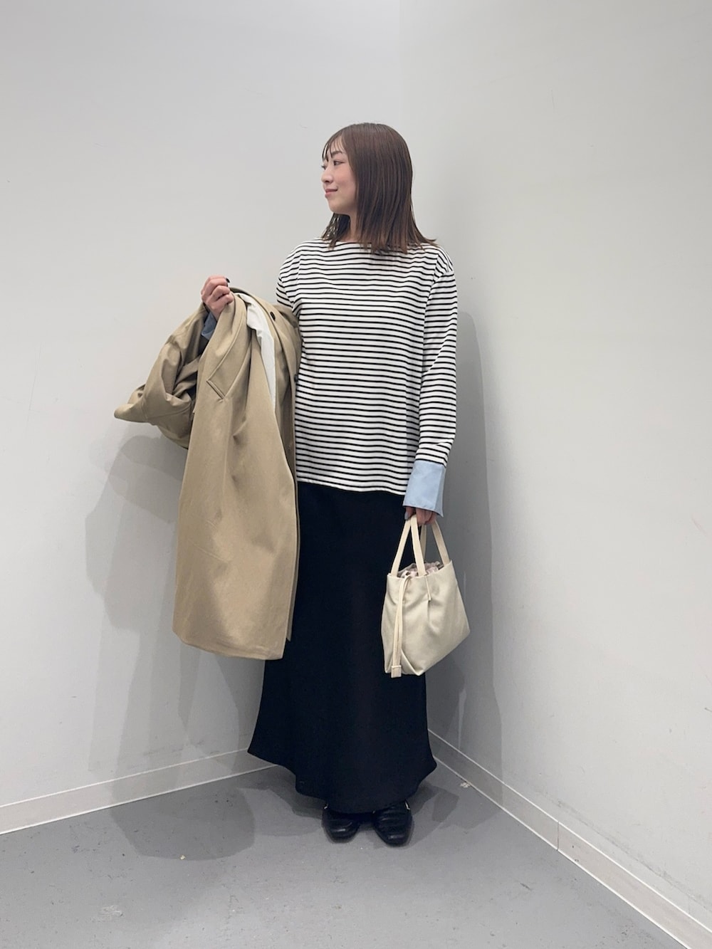 ベージュ系のその他アウター、ホワイト系のTシャツ/カットソー、ブラック系のスカートを着用したレディースの春コーディネートの4枚目の写真