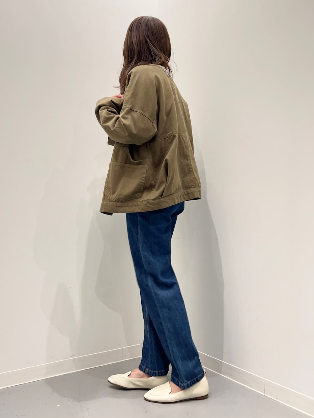 ブルー系のデニムパンツ、グリーン系のその他アウター、ホワイト系のTシャツ/カットソーを着用したレディースの秋コーディネートの3枚目の写真