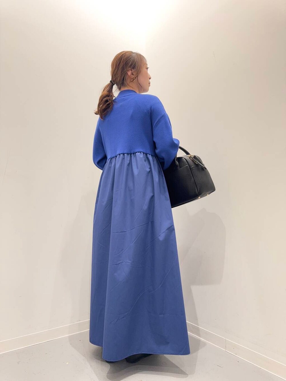 ブラック系のローファー、ブラック系のボストンバッグ、ブルー系のワンピースを着用したレディースの冬コーディネートの3枚目の写真