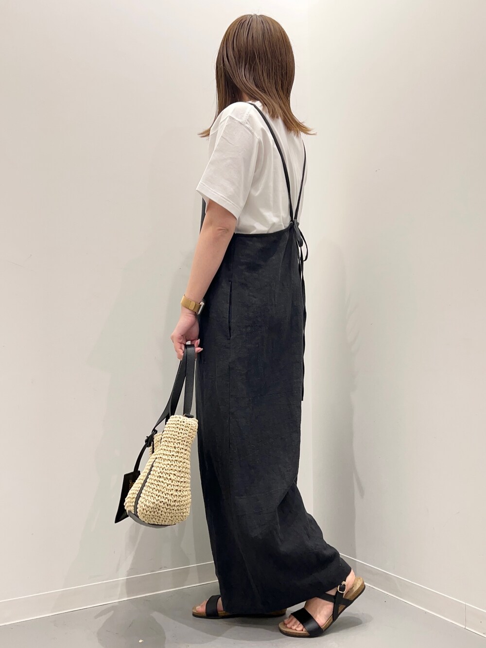 ホワイト系のTシャツ/カットソー、ブラック系のサロペット/オーバーオール、ブラック系のサンダルを着用したレディースの春コーディネートの5枚目の写真