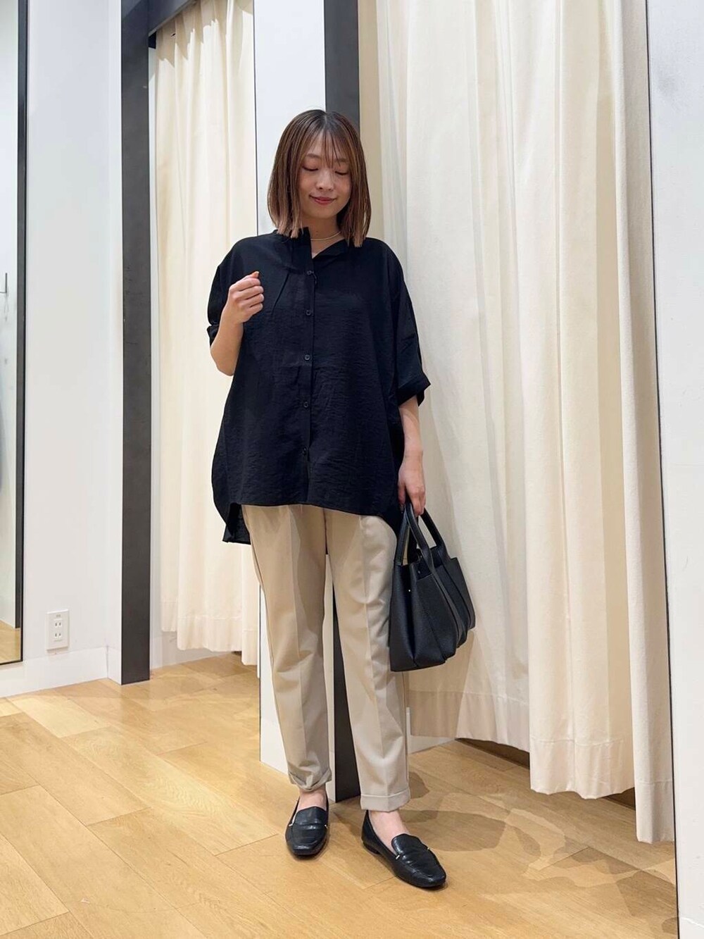 ブラック系のトートバッグ、ベージュ系のその他パンツ、ブラック系のシャツ/ブラウスを着用したレディースの夏コーディネートの2枚目の写真