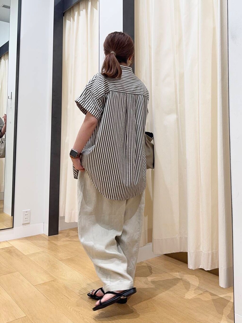 ベージュ系のショルダーバッグ、ブラック系のシャツ/ブラウス、ブラック系のサンダルを着用したレディースの夏コーディネートの3枚目の写真