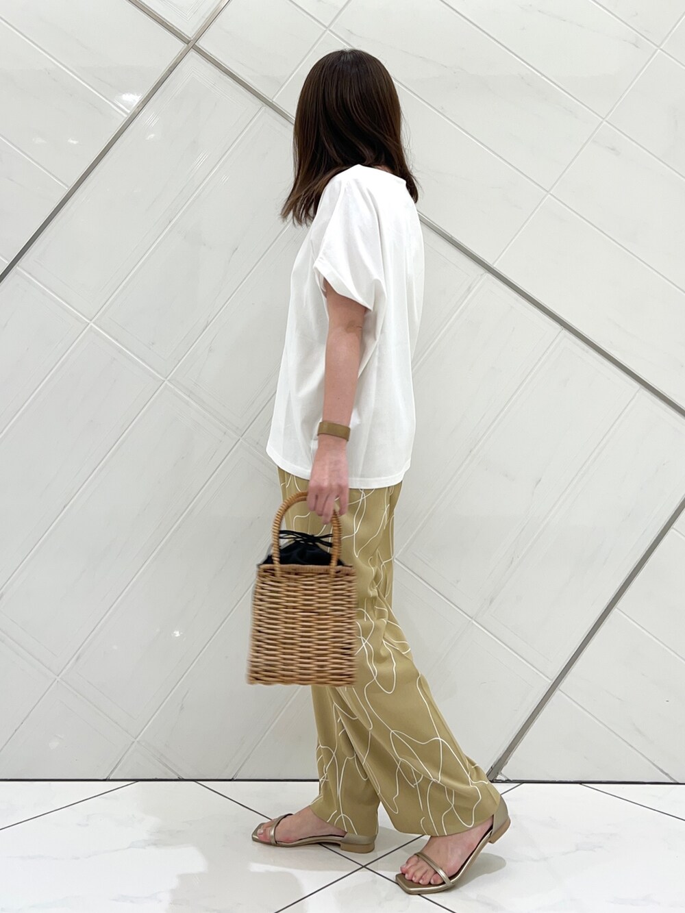 ホワイト系のTシャツ/カットソー、ベージュ系のその他パンツ、ゴールド系のサンダルを着用したレディースの夏コーディネートの3枚目の写真