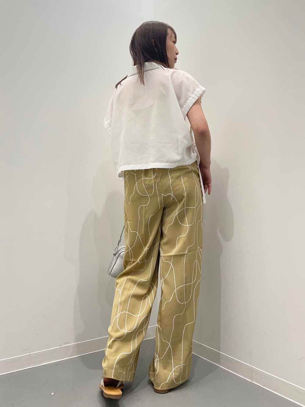 ホワイト系のシャツ/ブラウス、ベージュ系のその他パンツ、ホワイト系のサンダルを着用したレディースの夏コーディネートの5枚目の写真