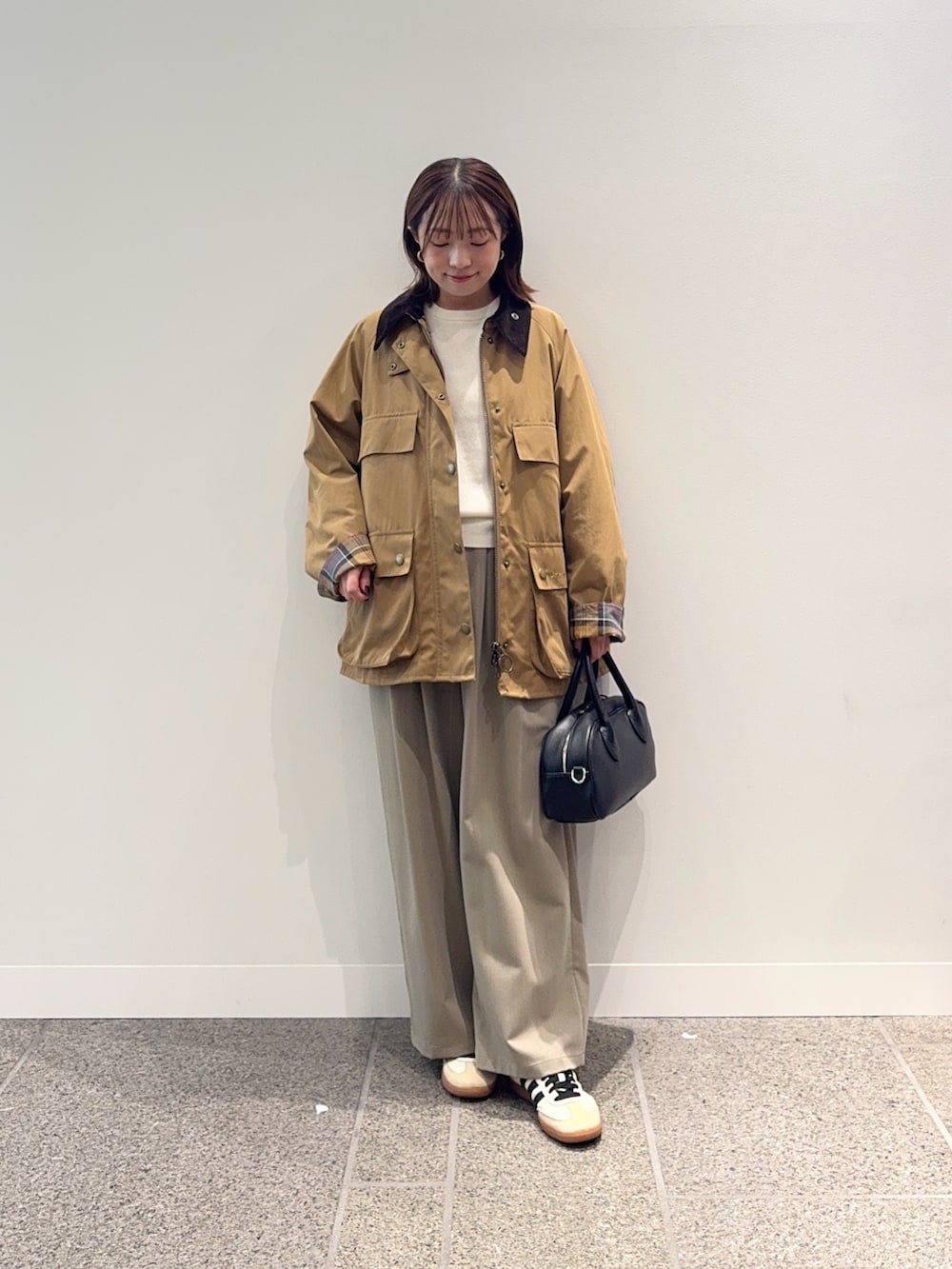 ベージュ系のその他アウター、ブラック系のショルダーバッグ、ベージュ系のスニーカーを着用したレディースの秋コーディネートの2枚目の写真