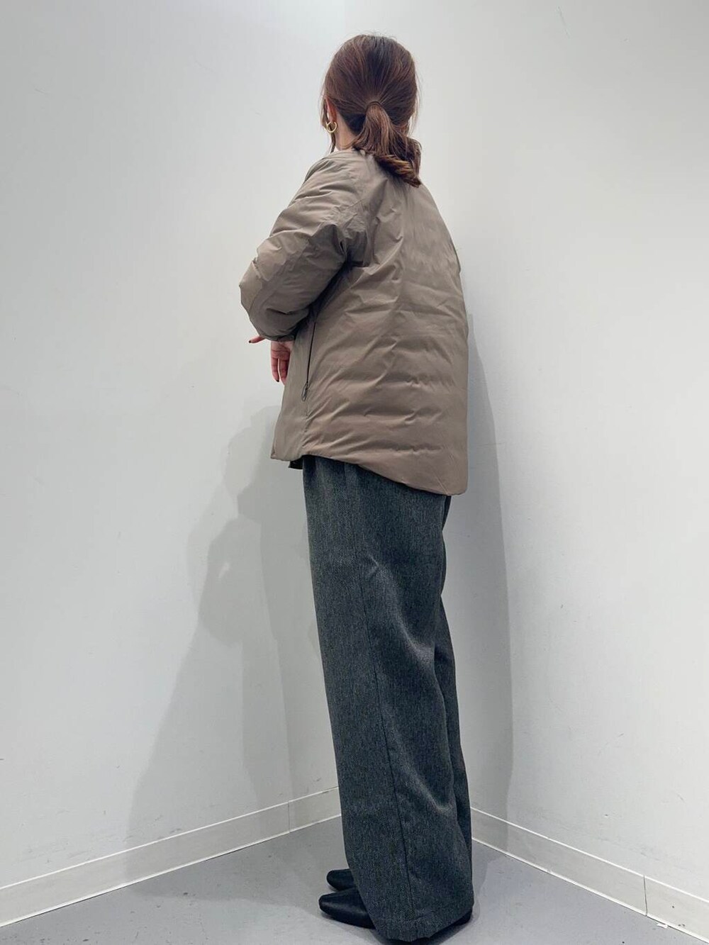 グレー系のその他パンツ、ベージュ系のニット/セーター、ブラウン系のダウンジャケット/コートを着用したレディースの冬コーディネートの2枚目の写真