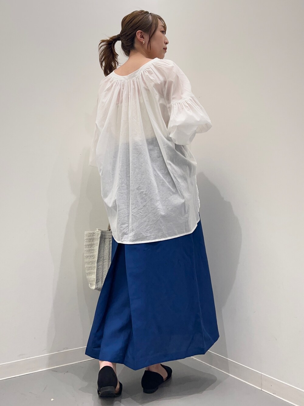 ホワイト系のシャツ/ブラウス、ブルー系のスカート、ベージュ系のトートバッグを着用したレディースの春コーディネートの3枚目の写真