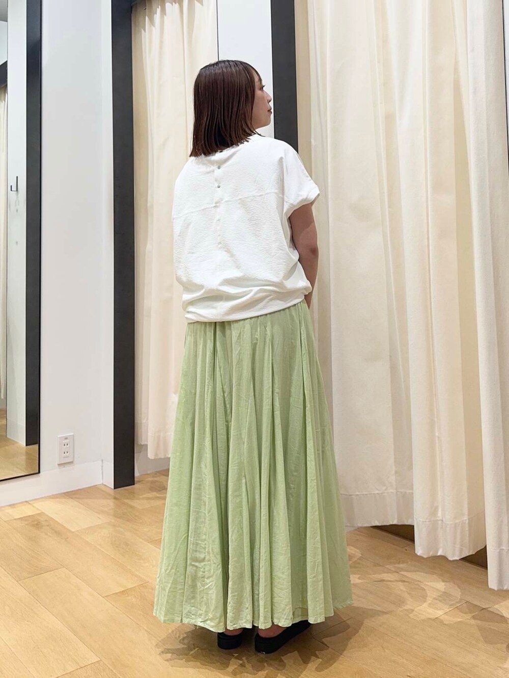 ブラック系のトートバッグ、ブラック系のサンダル、グリーン系のスカートを着用したレディースの夏コーディネートの4枚目の写真